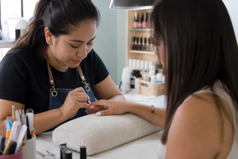 Manicurista atendiendo a una clienta