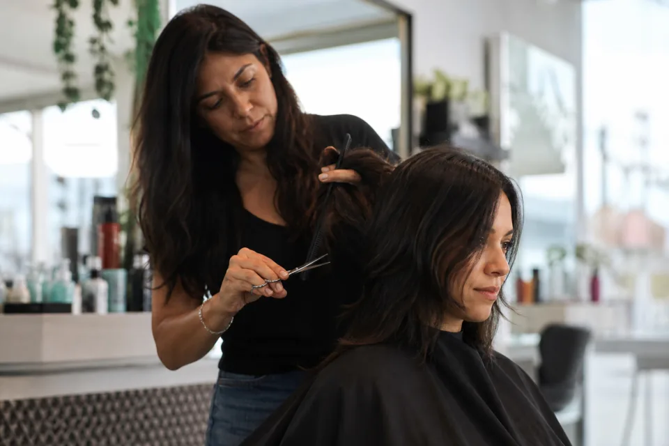 Peluquera cortando el cabello de una clienta